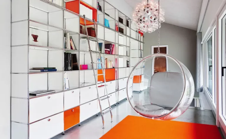 Système USM Haller étagère modulable tubes chromés et panneaux colorés.