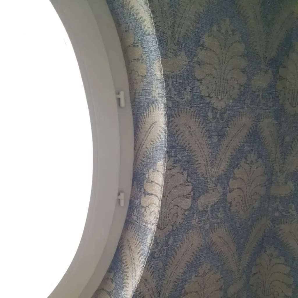 Fabric stretched around round window pinning detail