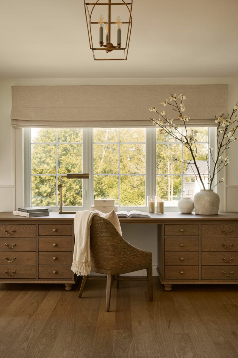 Bureau intégré en bois naturel dans la chambre principale du projet Deslandes par AKB Design, baigné de lumière naturelle et décoré de tons neutres et matières organiques.