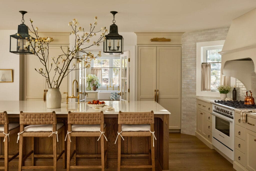 Cuisine du projet Deslandes par AKB Design, avec îlot central en bois, robinetterie dorée et finitions crème, illustrant un style intemporel et chaleureux.