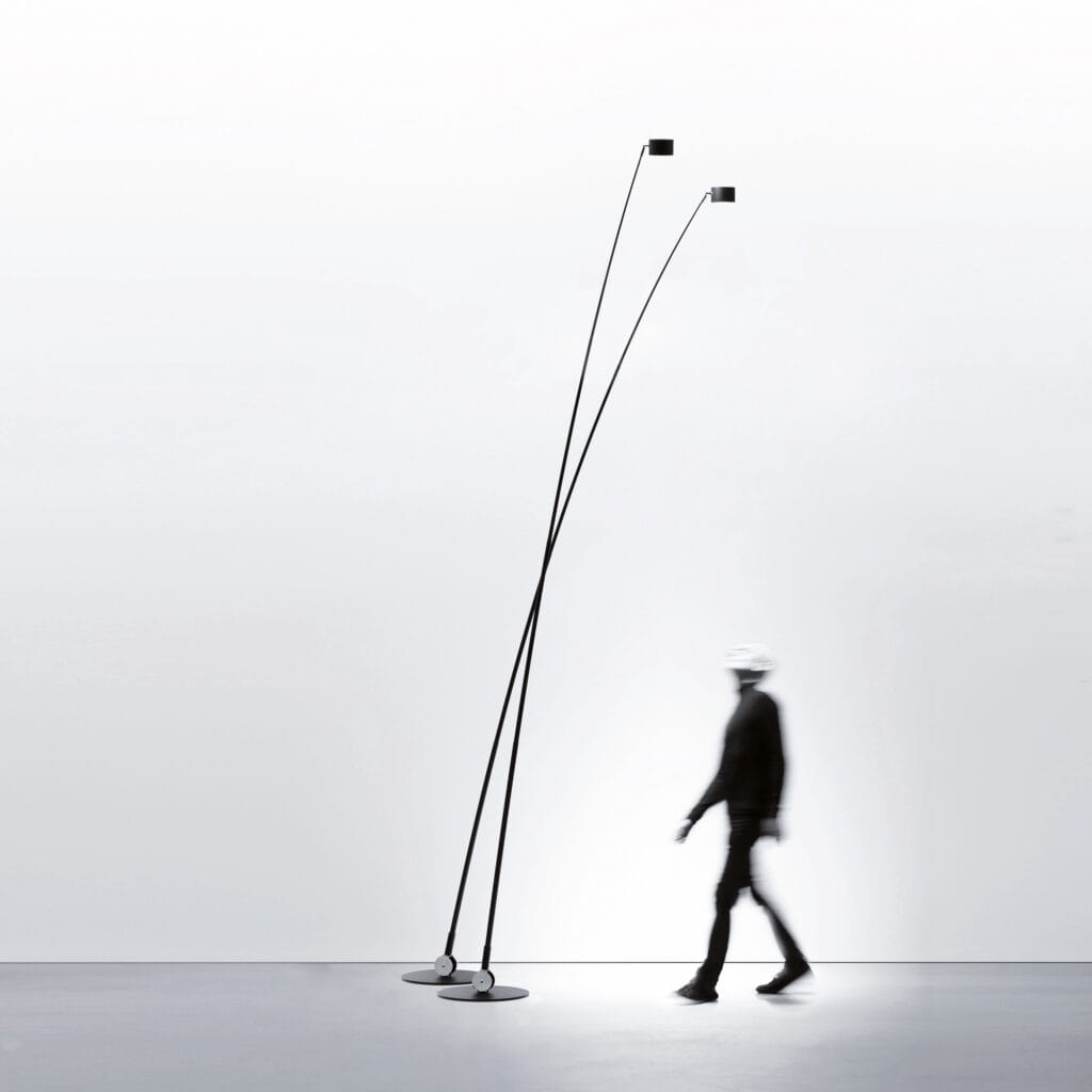 Lampe Sampei de Davide Groppi, grand luminaire élancé noir au design minimaliste, éclairant un espace contemporain avec une lumière directionnelle fine et poétique.