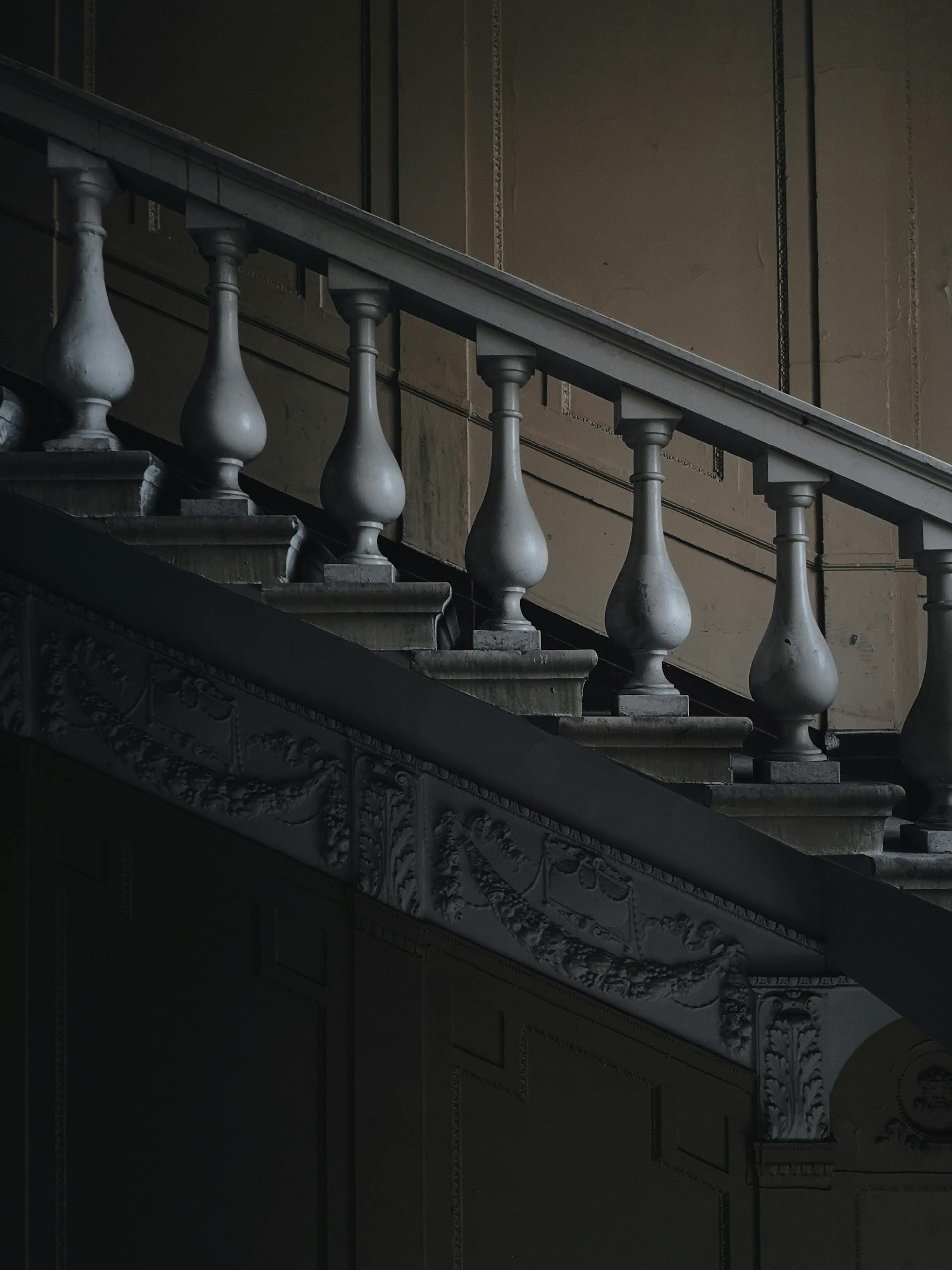 An elegant and classic staircase featuring intricate column details and rich, artistic decor.
