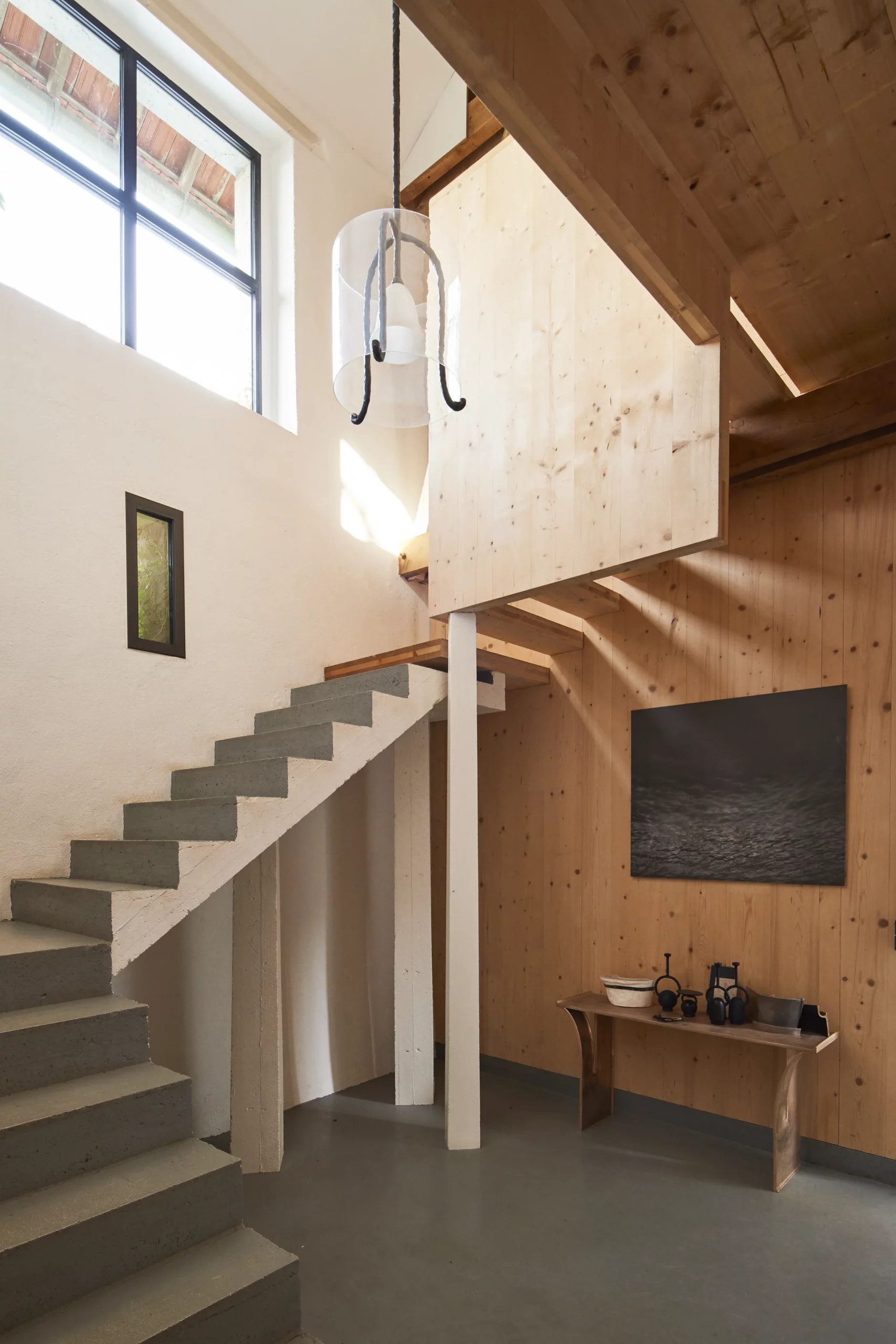 Concrete staircase connecting the studio to the living areas at Le Chapitre by Eric Schmitt