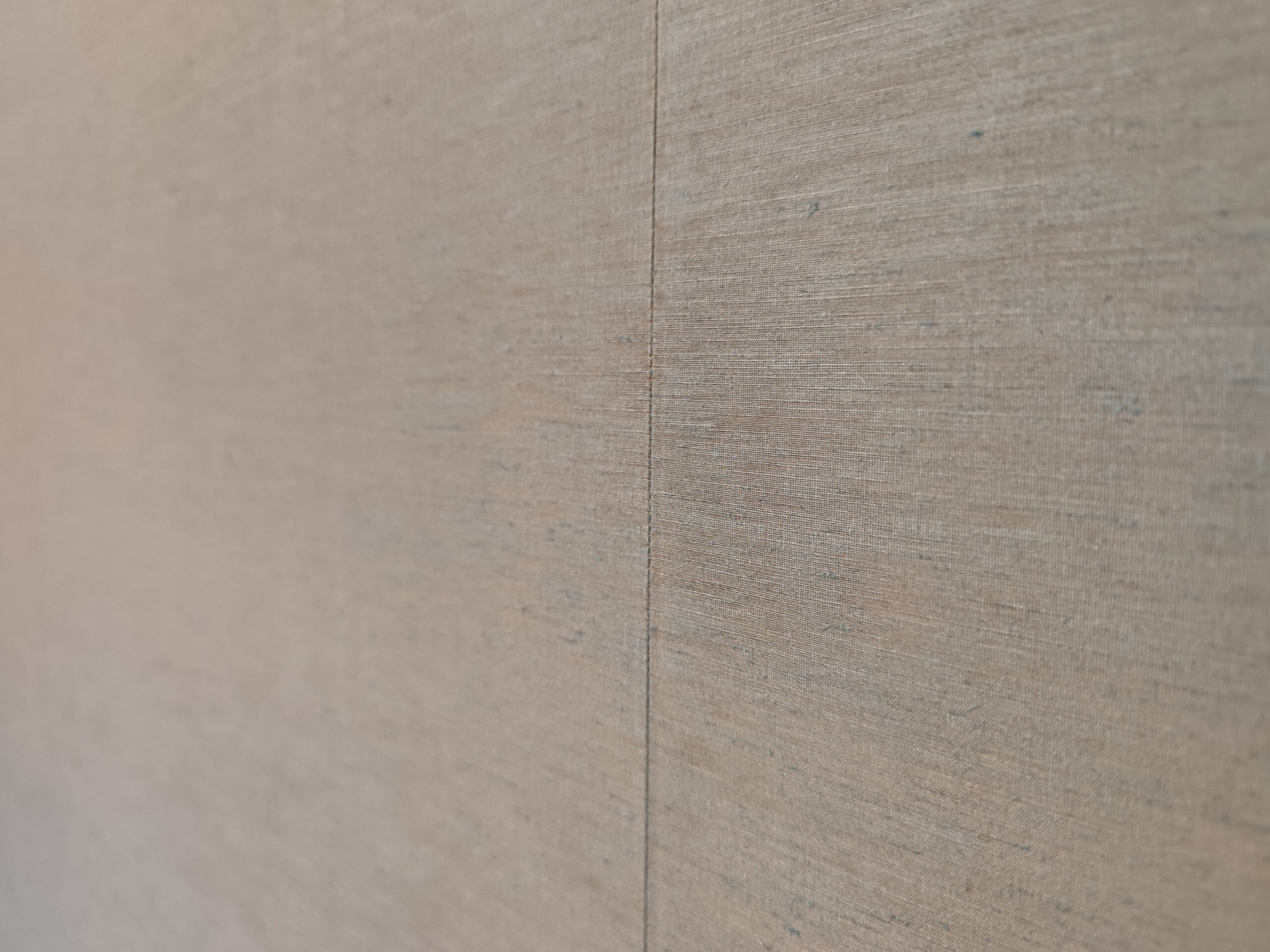 Close-up of a sewn seam join in plain fabric walling